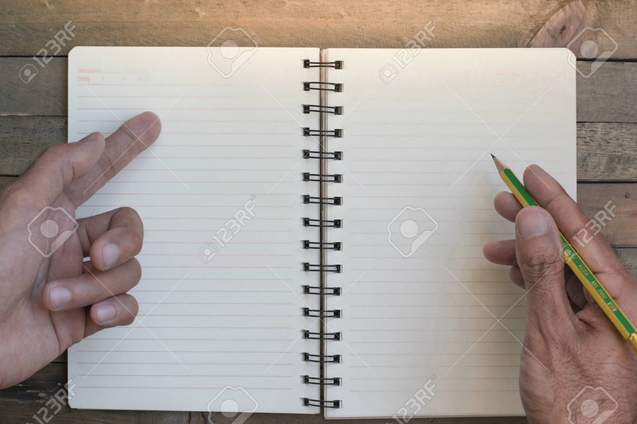 メモ帳や本に書く男 木の背景に紙 ノート教育 ビジネス コピースペース画像のための壁紙や背景を使用しています の写真素材 画像素材 Image