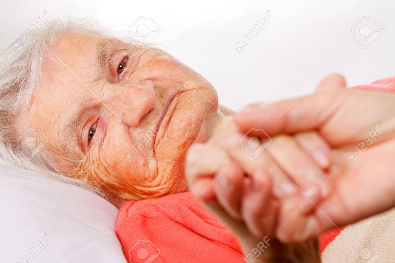 Caregiver holding elderly patients hand at home - 49825893 Caregiver holding elderly patients hand at home - 49825893