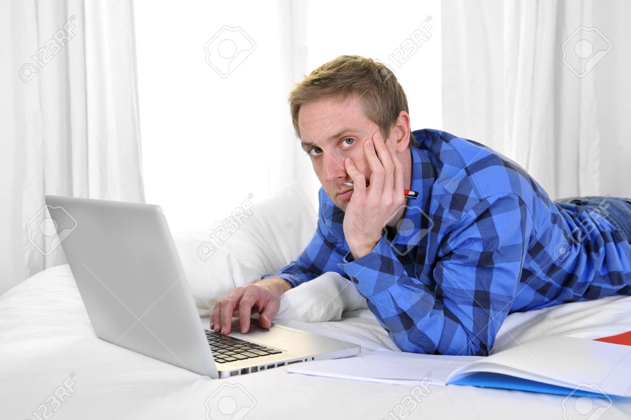 young attractive business man or busy student bored with computer