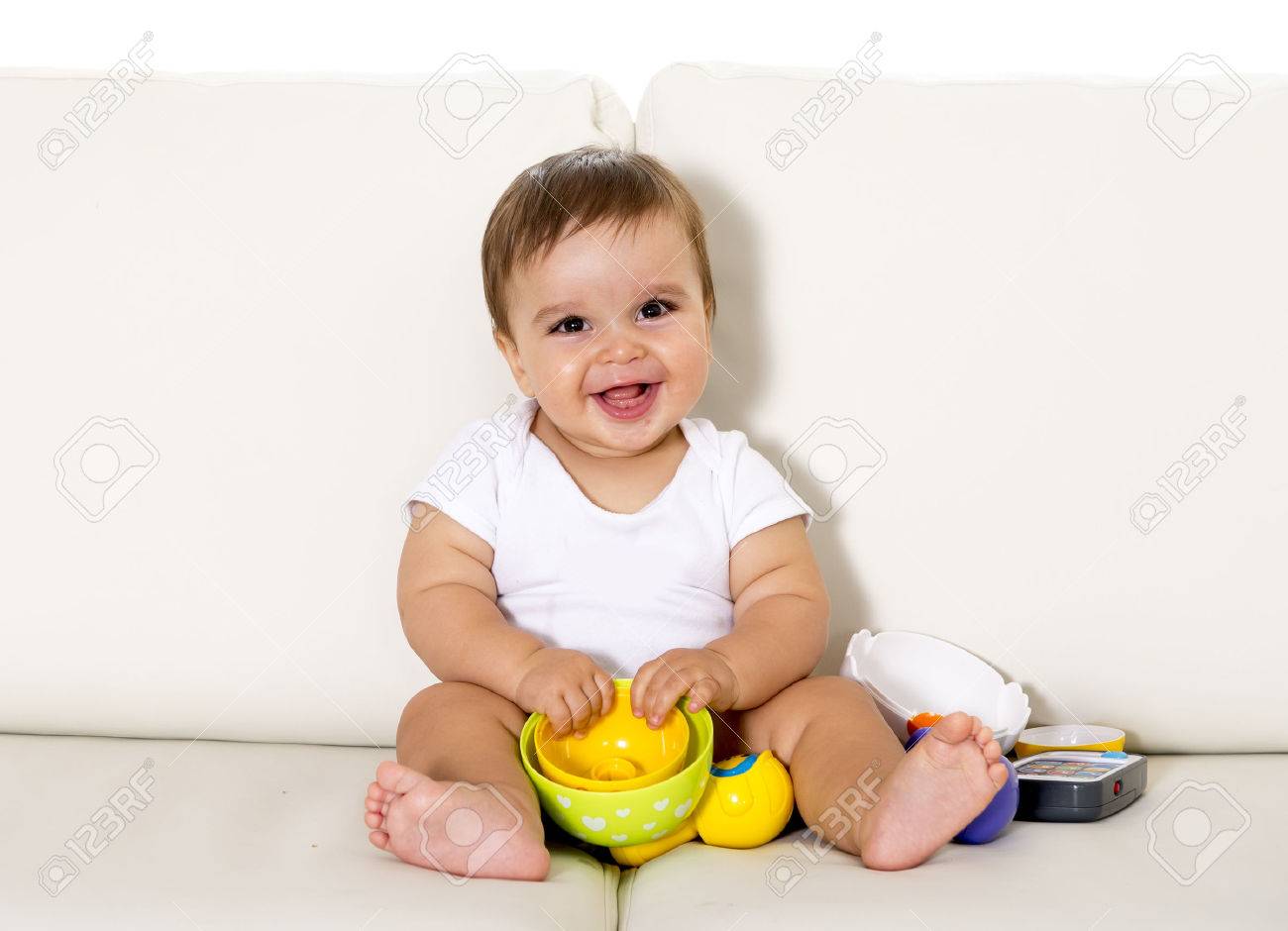 sweet cute little baby sitting on couch alone at home playing cute baby sitting