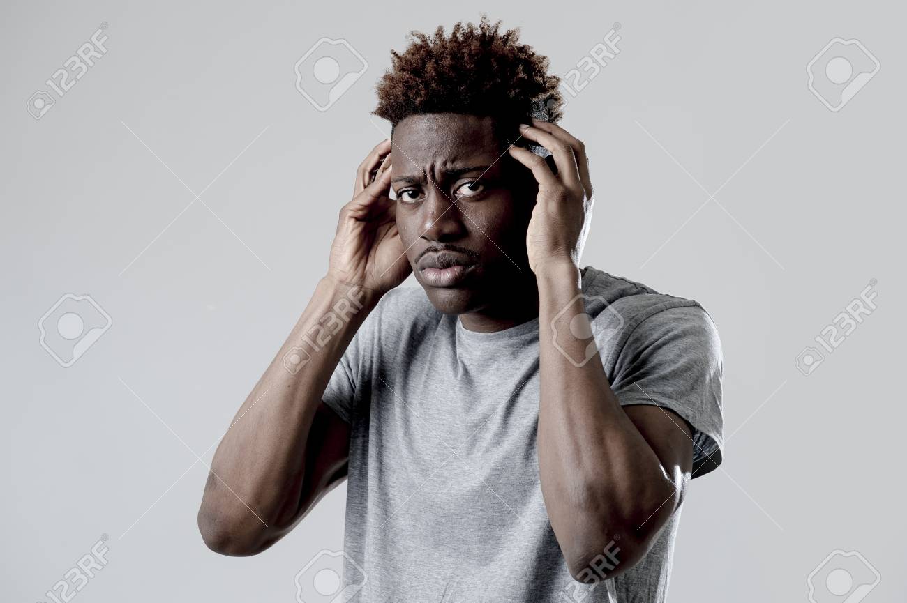 若い魅力的なアフロ アメリカ黒人表現見ると悲しい 疲れた顔疲れ頭痛とうつ病概念の灰色の背景に分離された片頭痛に苦しんでいます の写真素材 画像素材 Image