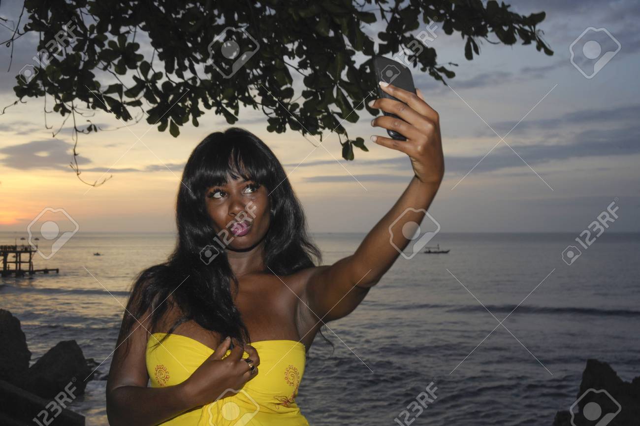 若い魅力的なと華やかなアフリカ系アメリカ人の黒人女性シックな夏のドレスの休日旅行ソーシャル メディア更新概念のサンセットビーチでの携帯電話の Selfie 画像や動画を撮影 の写真素材 画像素材 Image 若い魅力的なと華やかなアフリカ系アメリカ人の黒人女性シックな夏のドレスの休日旅行ソーシャル メディア更新概念のサンセットビーチでの携帯電話の Selfie 画像や動画を撮影 の写真素材 画像素材 Image
