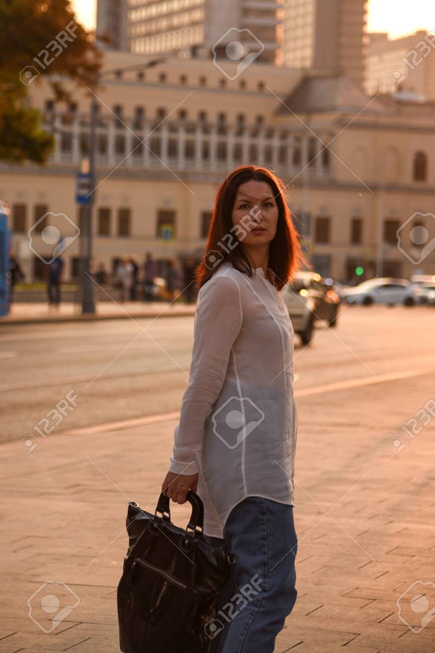 A Single Woman 40 Years Old In A White Blouse Posing In The City Stock Photo Picture And Royalty Free Image Image 130579646