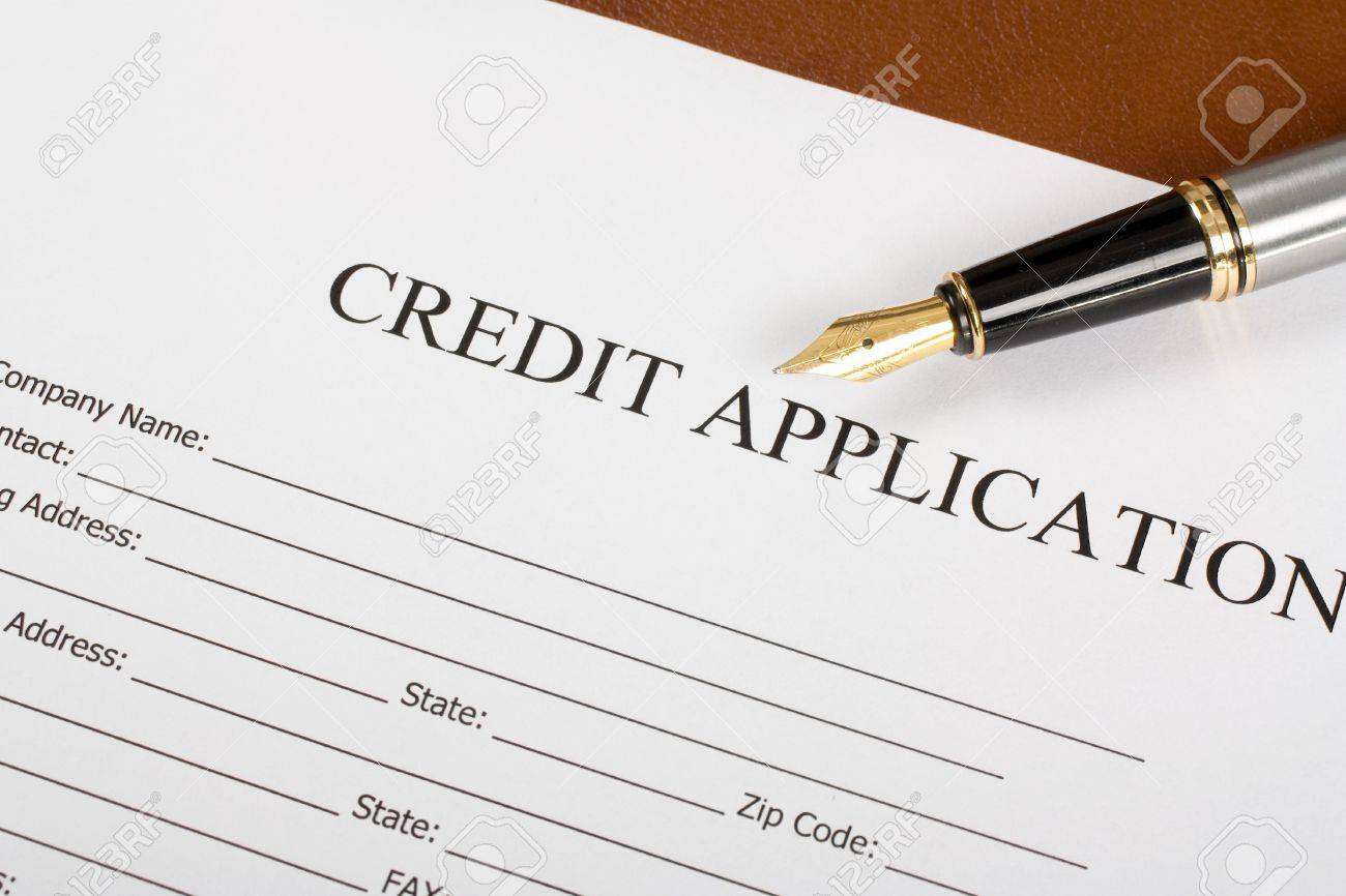 blank credit application form and pen on desktop stock photo