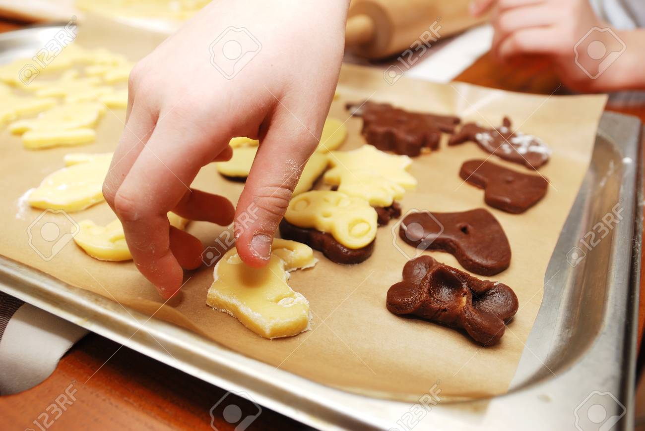childrens hands making christmas cookies with metal cutter close up stock photo - Making Christmas Cookies childrens hands making christmas cookies with metal cutter close up stock photo - Making Christmas Cookies