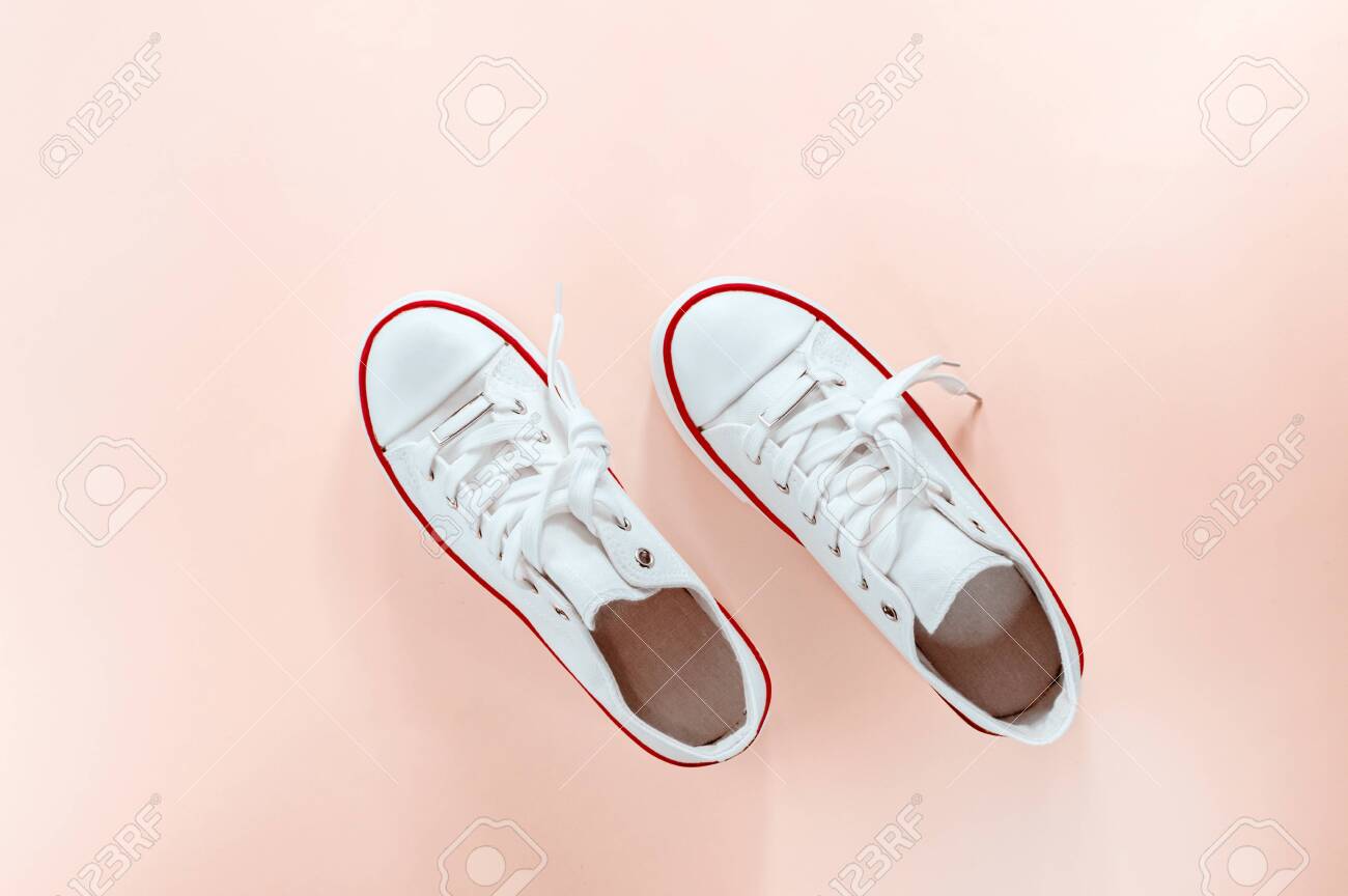 Zapatillas De Moda Blancas Sobre Fondo Melocotón Cremoso. Vista Plana Endecha, Superior. Lugar El Texto. Composición De Estilo Ropa Deportiva, Concepto De De Vida Activo. Fotos, Retratos, Imágenes