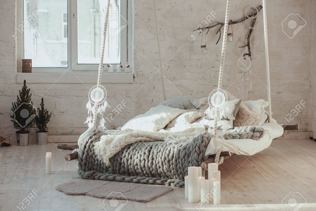 Le lit suspendu au plafond, un lit inhabituel. Gris grande couverture confortable tricotée. Lit, style scandinave, plaid gris. Le lit suspendu au plafond, un lit inhabituel. Gris grande couverture confortable tricotée. Lit, style scandinave, plaid gris.