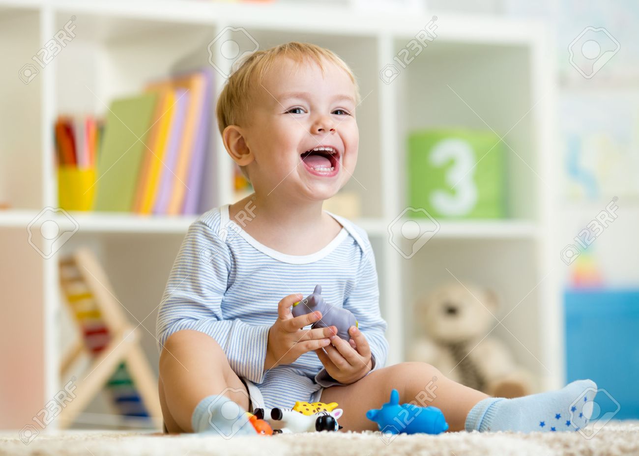 Happy little boy. Smiling child toddler plays animal toys at home or kindergarten. - 43207339 Happy little boy. Smiling child toddler plays animal toys at home or kindergarten. - 43207339