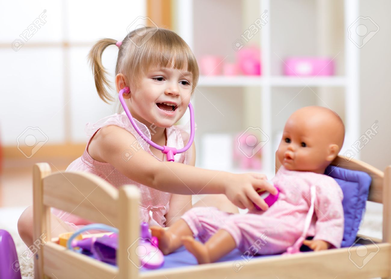 child in kindergarten kid in nursery school little girl playing doctor with doll stock - Little Kid Pictures child in kindergarten kid in nursery school little girl playing doctor with doll stock - Little Kid Pictures