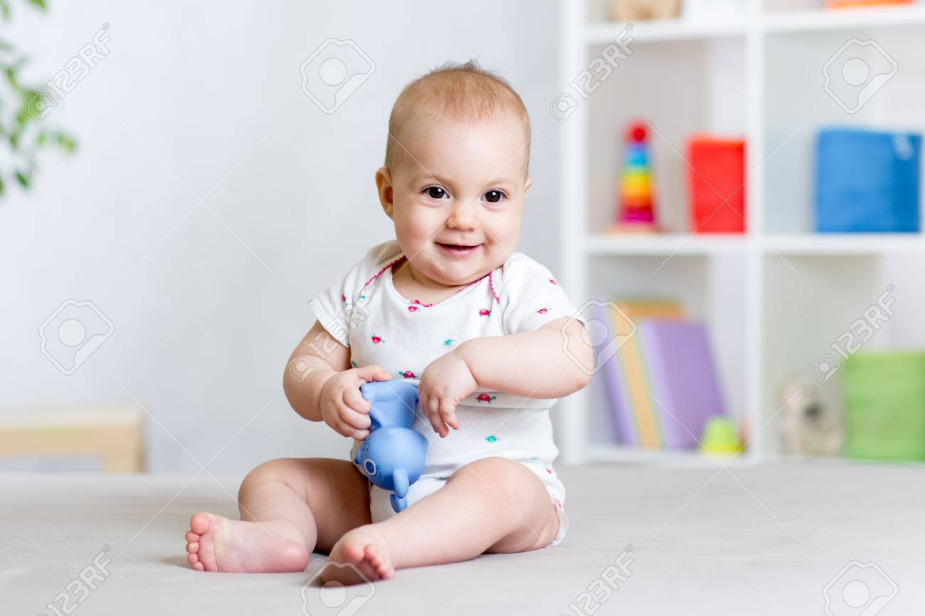 cheerful baby playing with toy at home - 54307406 cheerful baby playing with toy at home - 54307406
