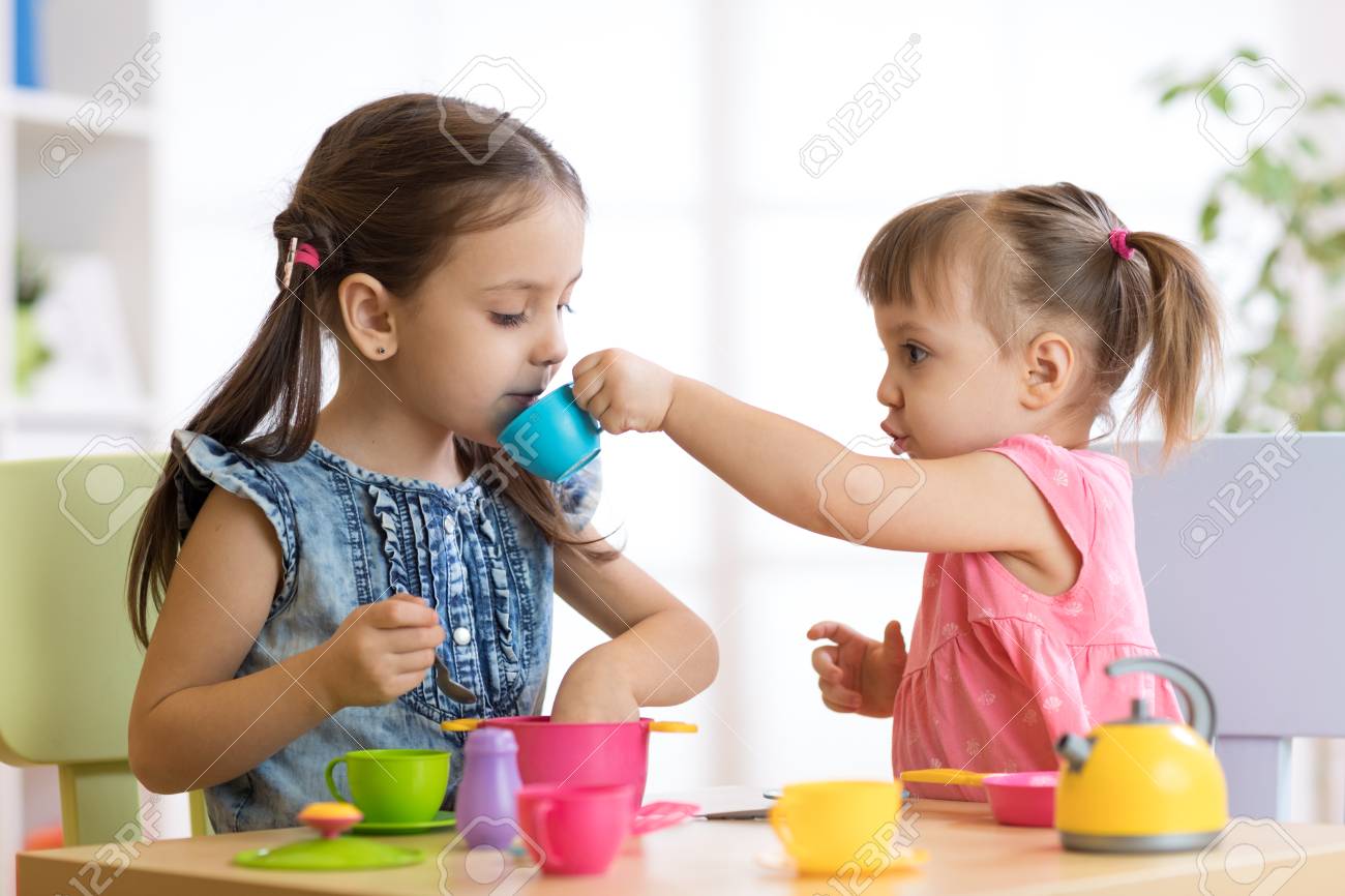 niñas jugando con cocinitas