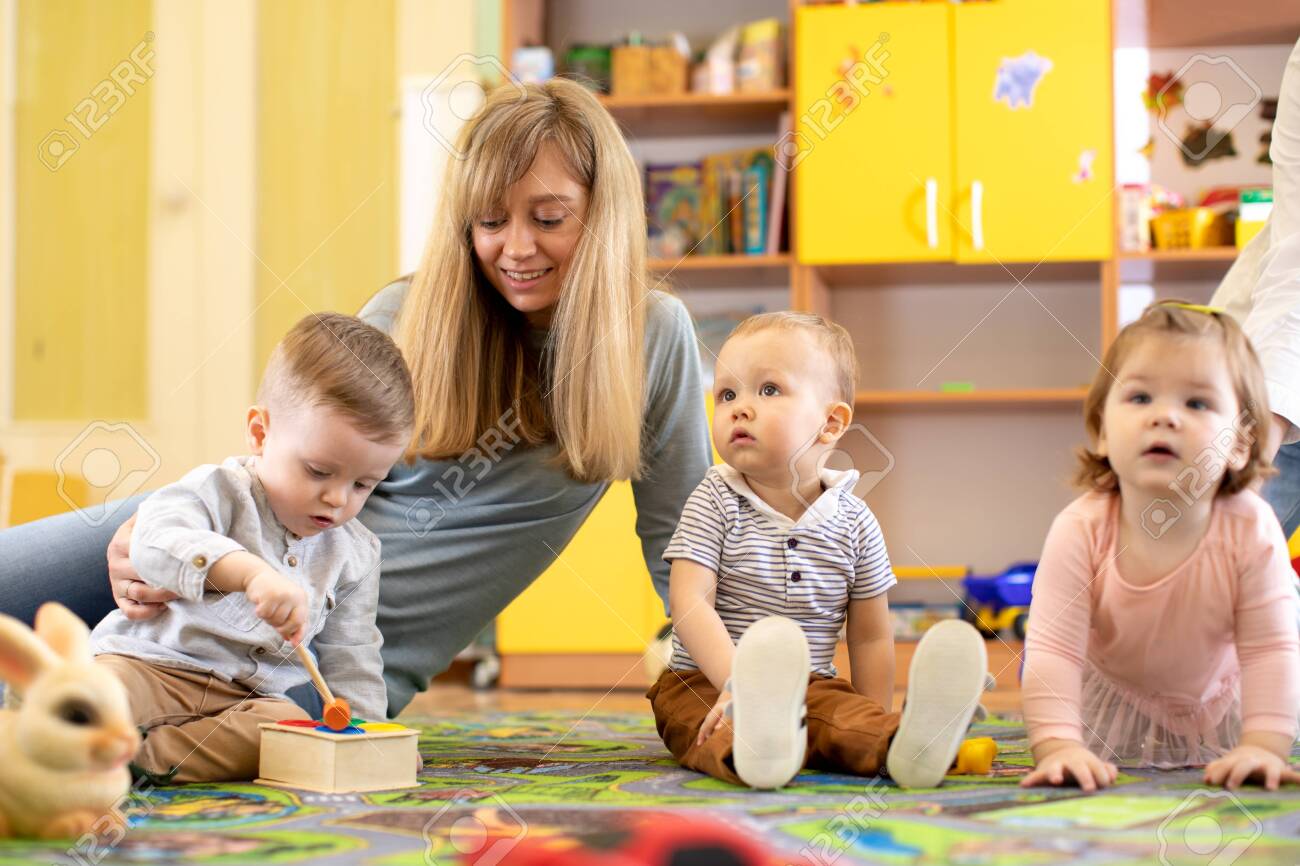 nursery teacher looking after children in daycare little kids teacher toddler