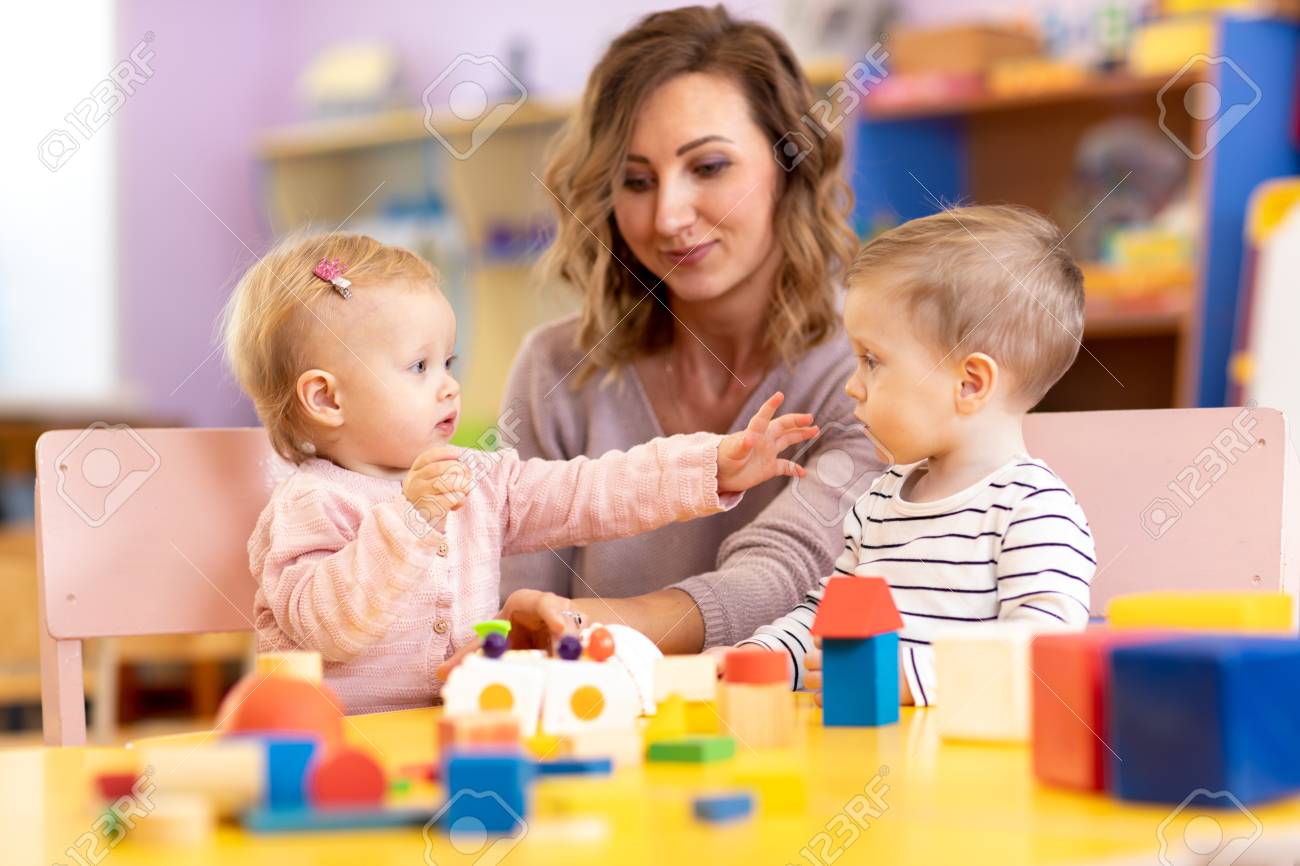 Babies in kindergarten. Kids toddlers in nursery school. Little girl and boy preschoolers playing with teacher. - 122596692 Babies in kindergarten. Kids toddlers in nursery school. Little girl and boy preschoolers playing with teacher. - 122596692