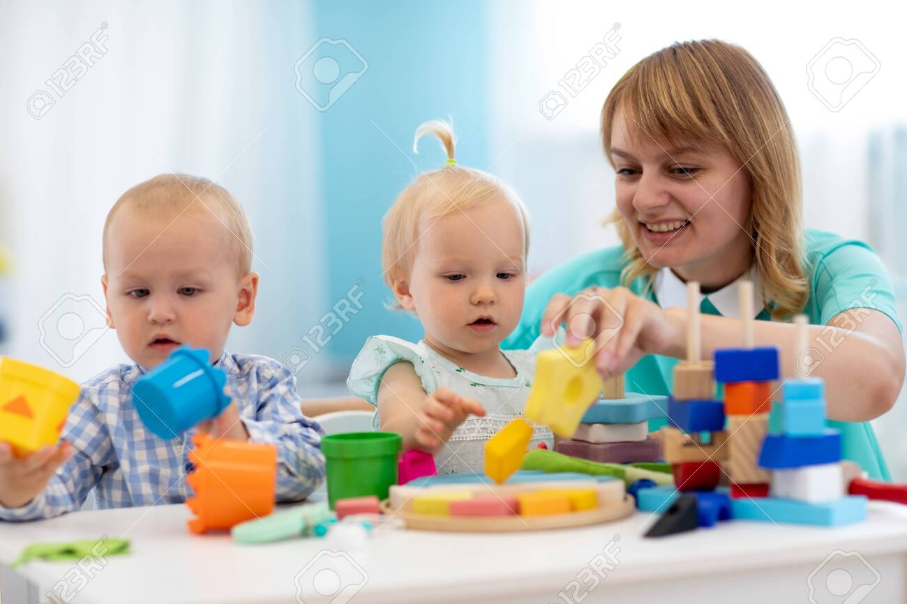 nursery teacher looking after children in daycare little kids teacher toddler