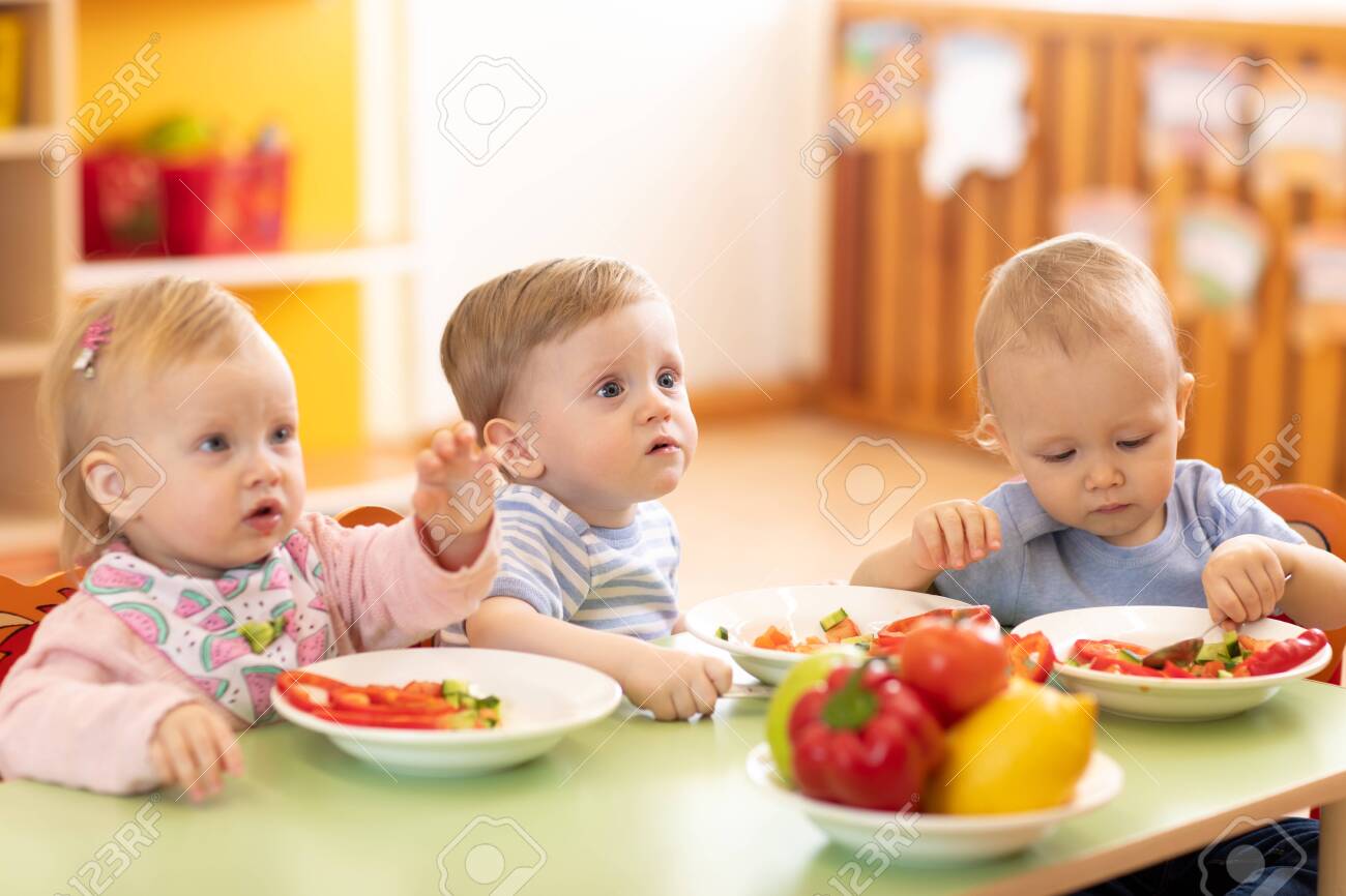 Kids eating in kindergarten or day care centre - 135036713 Kids eating in kindergarten or day care centre - 135036713