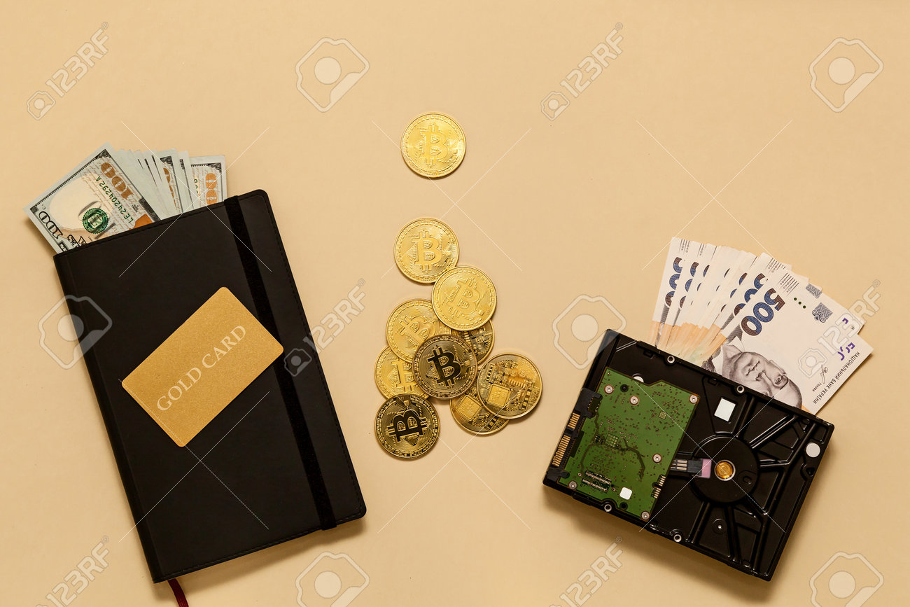 베이지색 배경의 테이블 골드 비트코인 달러 일기 골드 카드 하드 디스크에 있는 비즈니스 개념 항목 비트코인은 무역과 화폐 교환을 위한  세계 시장인 디지털 통화입니다. 로열티 무료 사진, 그림, 이미지 그리고 스톡포토그래피. Image