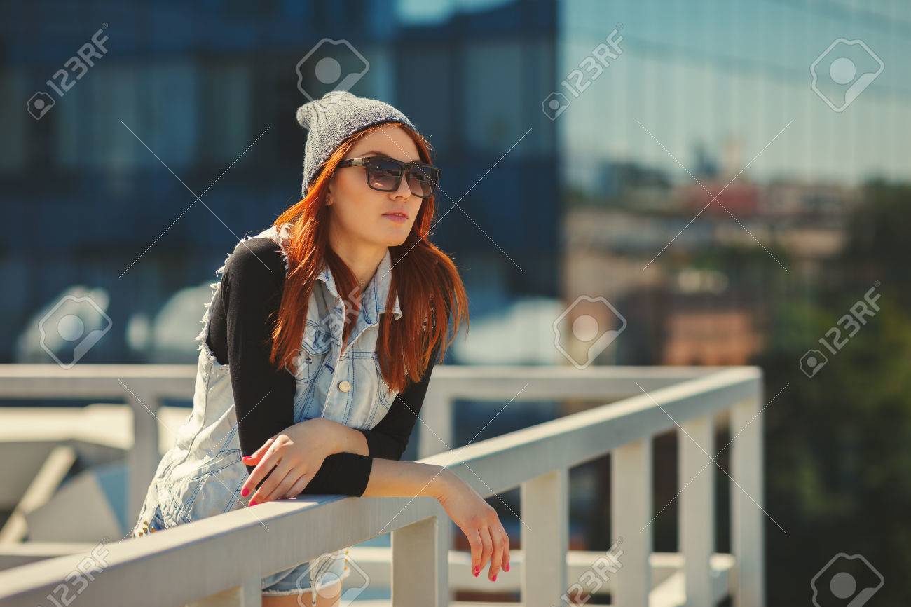 Outdoor fashion lifestyle portrait of pretty young girl, wearing in hipster swag grunge style urban