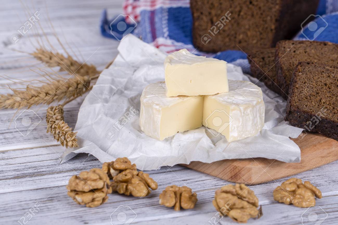 ブリーチーズやカマンベール チーズ 新鮮なブリーチーズ チーズとクルミの木の板にスライスと黒のパンのスライス イタリア語やフランス語のチーズ クローズ アップ の写真素材 画像素材 Image
