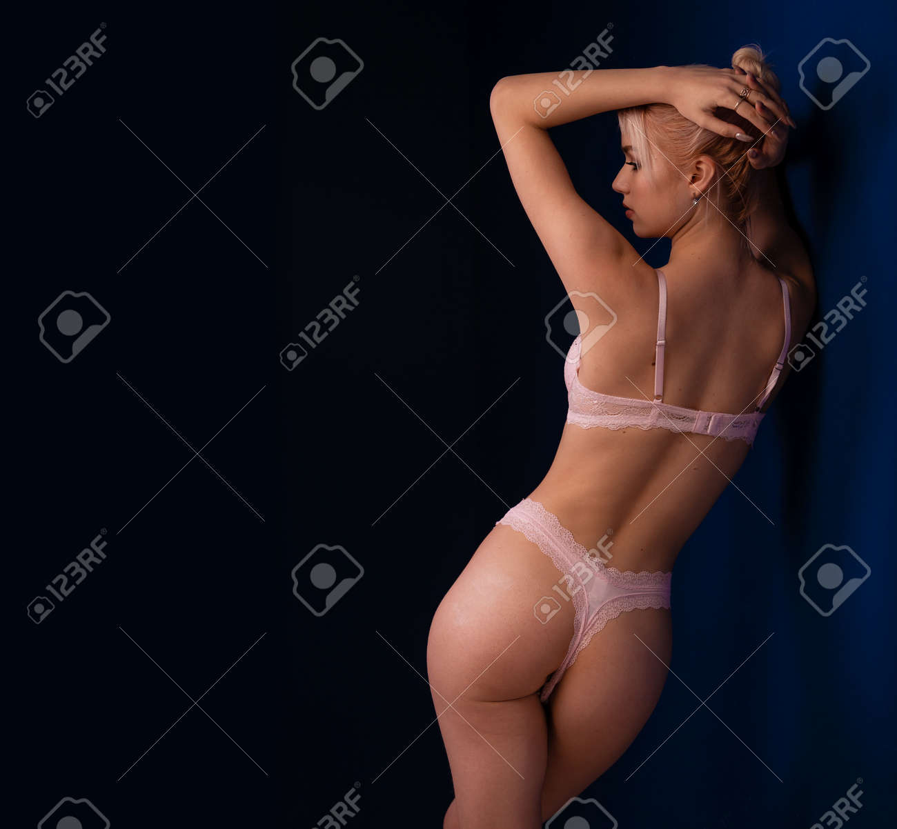 魅惑の下着美女 魅惑的なピンクのランジェリーで後ろから見た女性。魅力的な誘惑美女。濃紺の背景に下着の官能的なスリムフィットボディを宣伝するテキスト用の空きスペースの写真素材・画像素材  Image 180342923