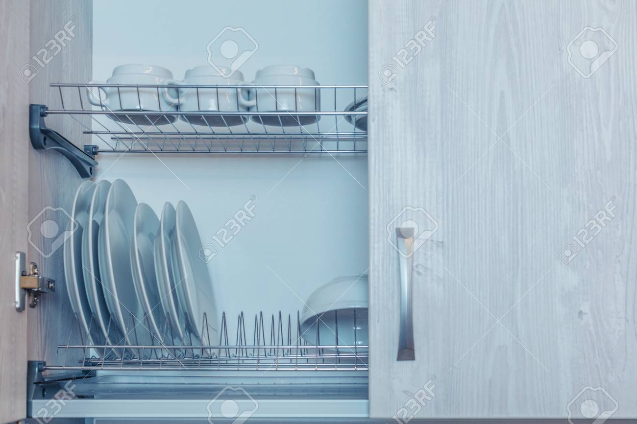Plates Are Dried On A Shelf For Dishes In The Kitchen Cabinet Stock Photo