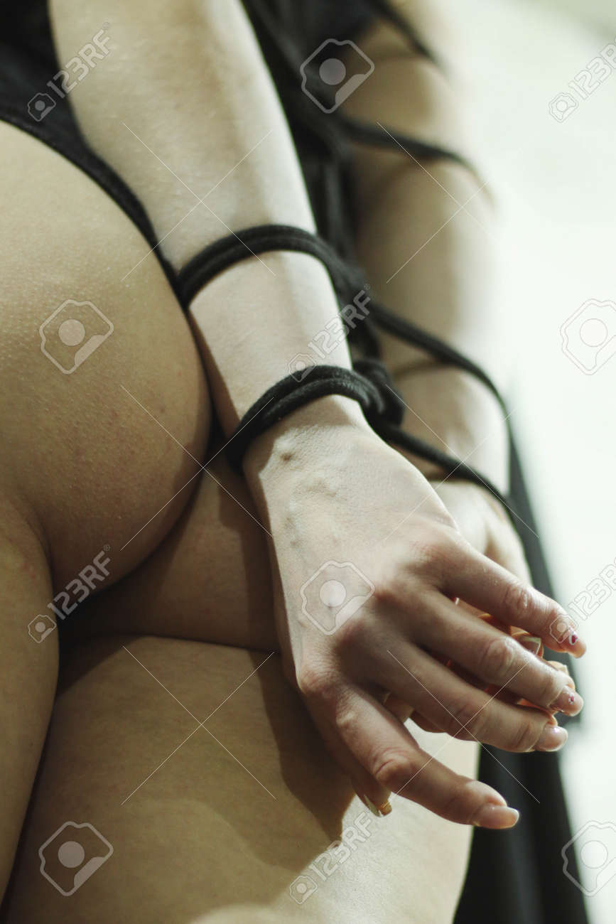 縛りトラストブリッジトンボの女は、日本の伝統的な縛りに包まれ、ロープで縛られ、緊縛されています。僧侶の背景に背中の後ろの手が結ぶプロセスを写真に撮る、の写真素材・画像素材  Image 165575366