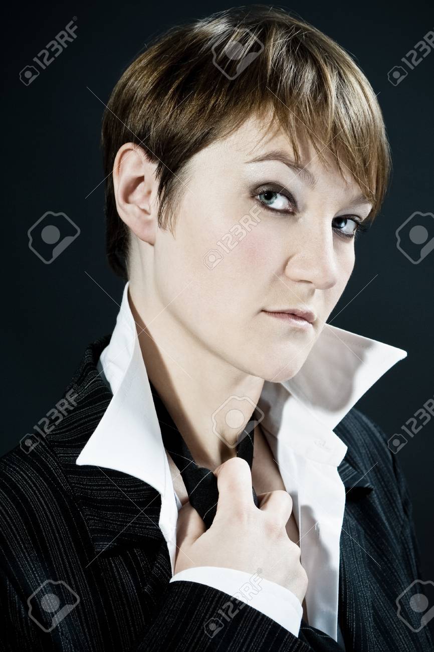 Woman With Short Hair Cut Wearing Business Suit Takes Off Tie