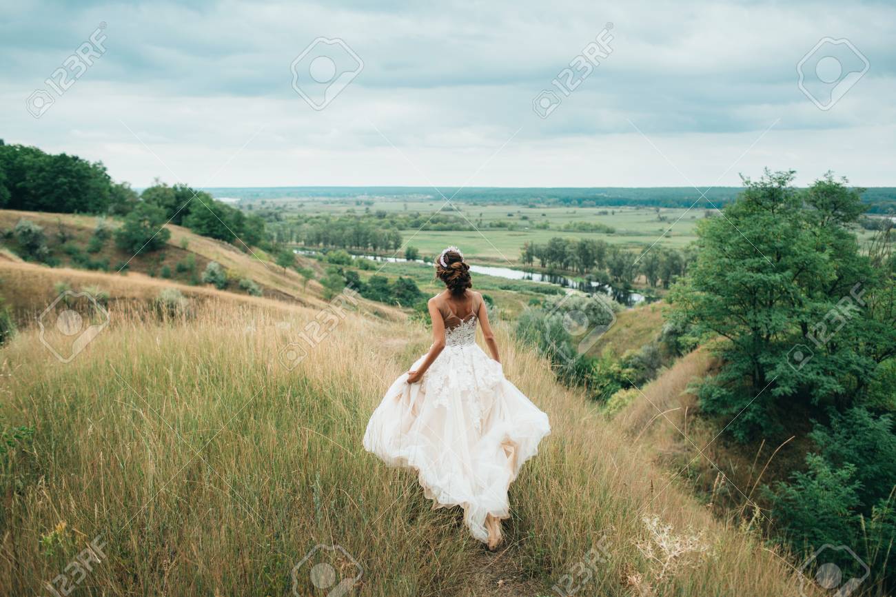 A Happy Bride Is Running In A Wedding Dress, Against A Backdrop Of  Beautiful Nature. Bride Spinning Around With Veil. Stock Photo, Picture and  Royalty Free Image. Image 90867767., image size:1300x866