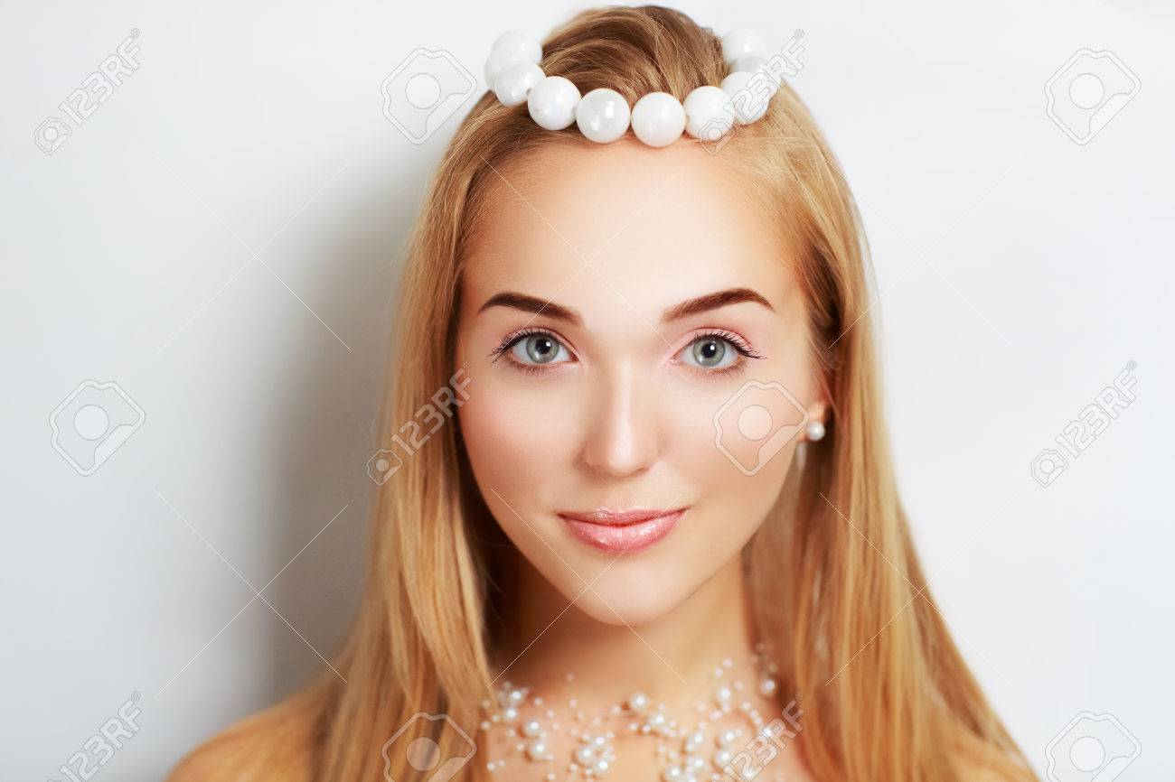 天使のような顔と美しいアクセサリー大小の真珠から魅力的な女の子 きれいな若い女性 スマイリー ピンク セクシーな唇 完璧な形の茶色眉 大きな目 黄金の ストレートの髪 ヌード の写真素材 画像素材 Image