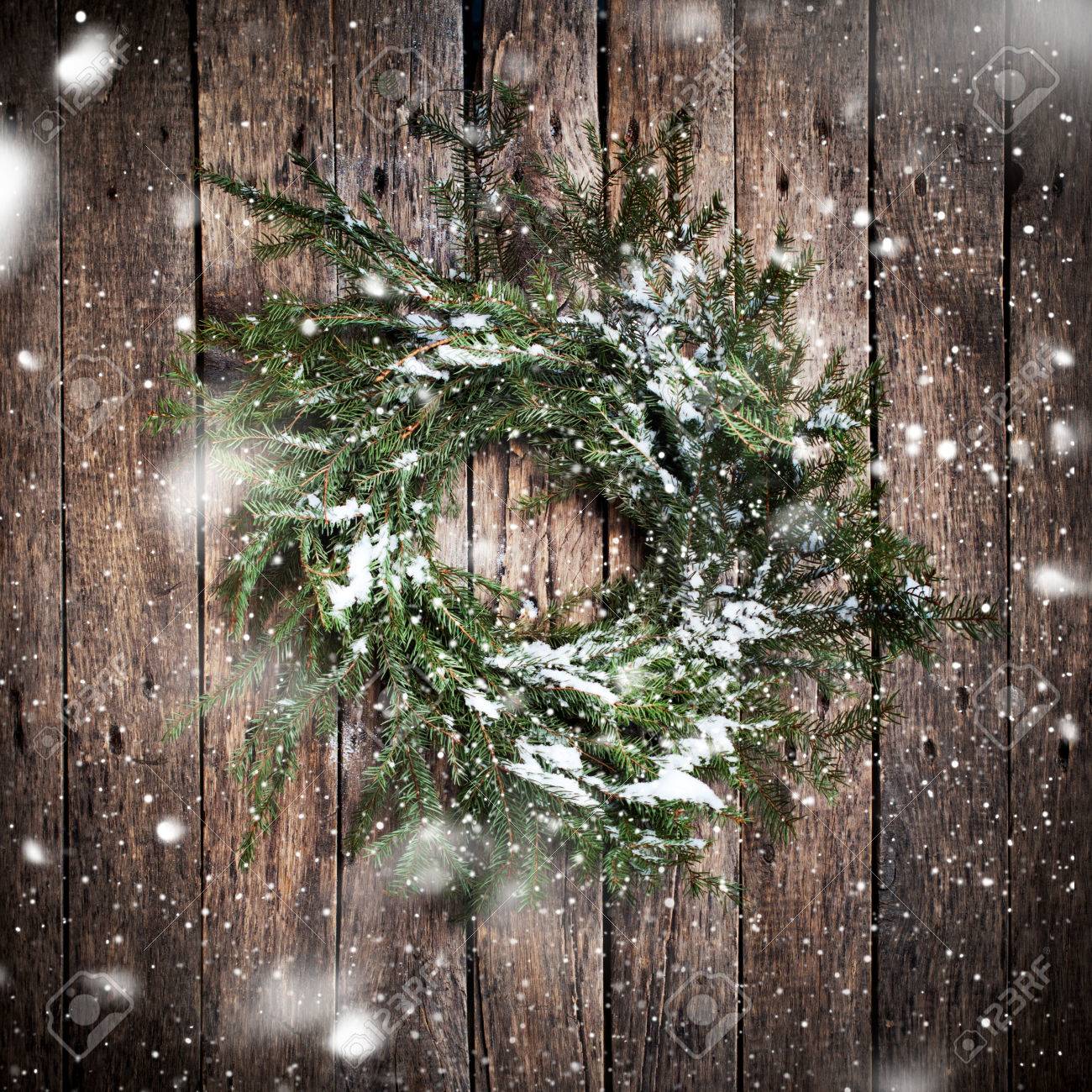 Green Natural Wreath on Wooden Background with drawing Falling Snow. Vintage Style - 46933221 Green Natural Wreath on Wooden Background with drawing Falling Snow. Vintage Style - 46933221