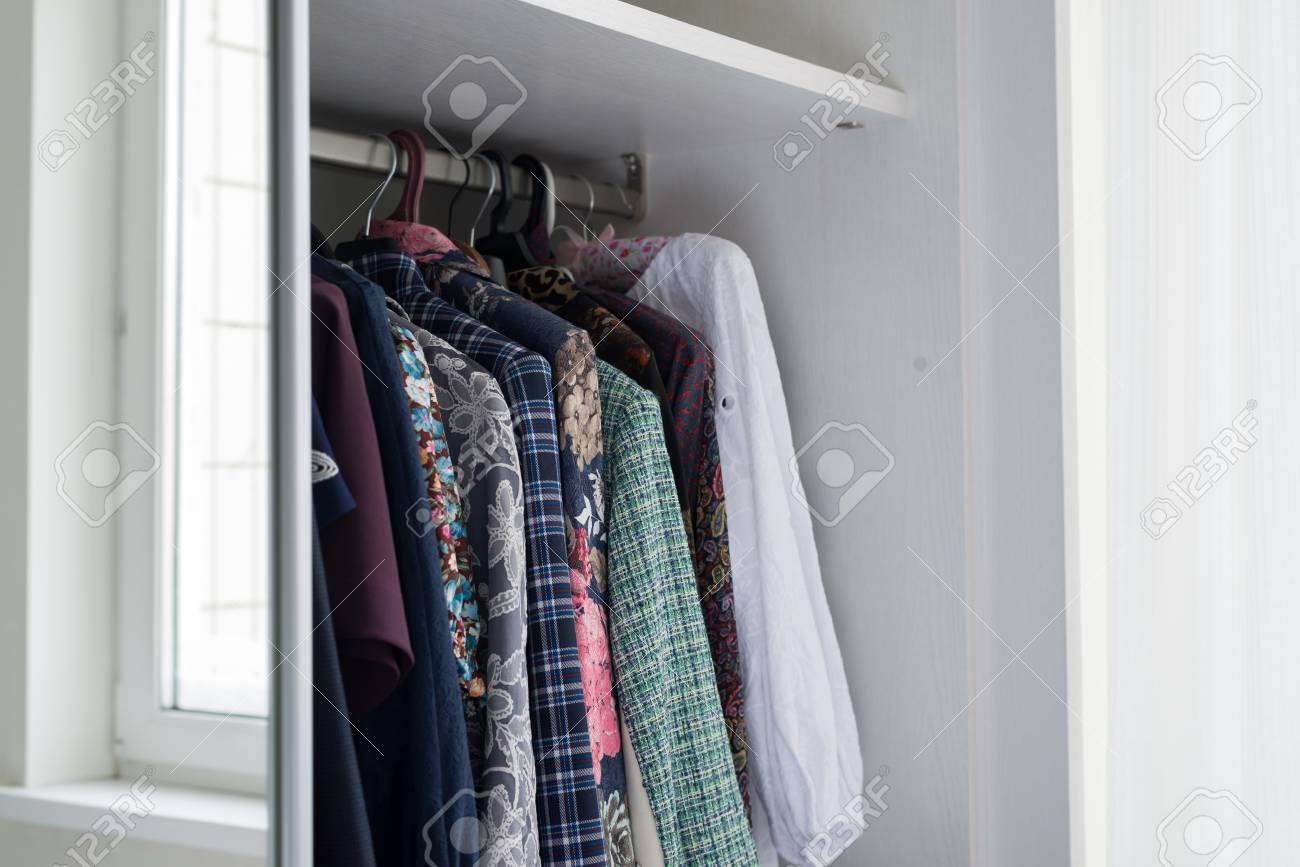 Women S Clothes Hanging In An Open White Cabinet Stock Photo
