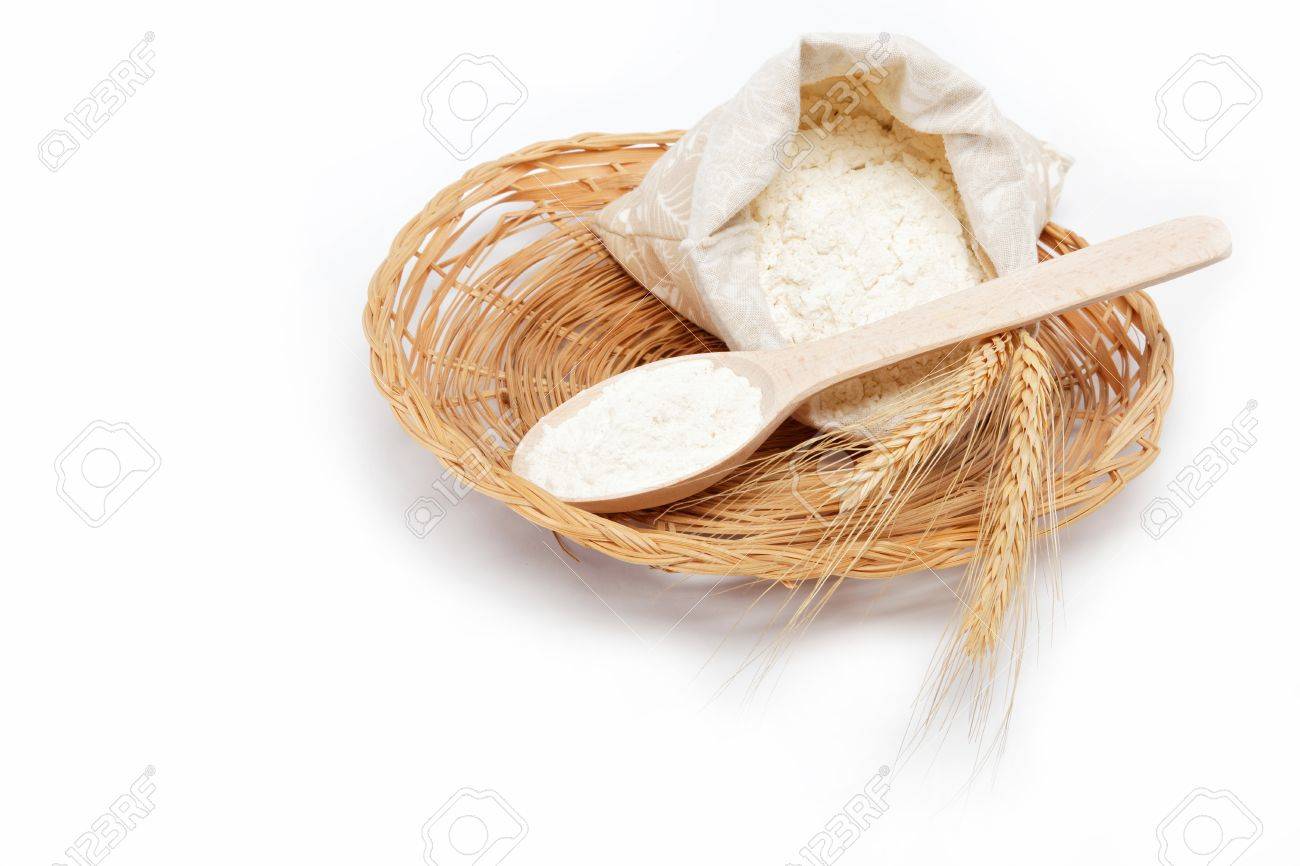 Flour and wheat grain with wooden spoon on a wicker basket. - 15496354 Flour and wheat grain with wooden spoon on a wicker basket. - 15496354