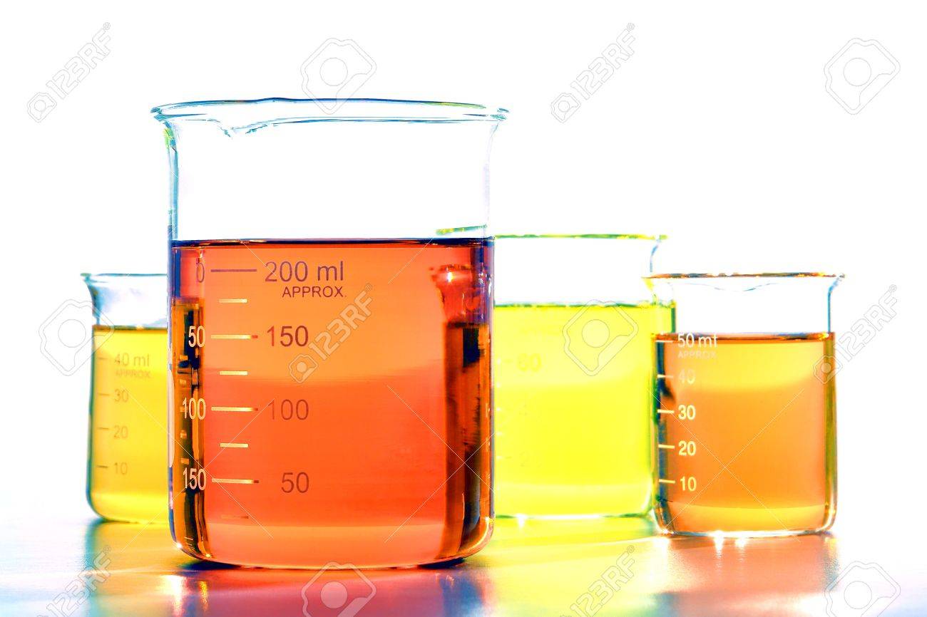 assorted sizes glass scientific beakers filled with orange and