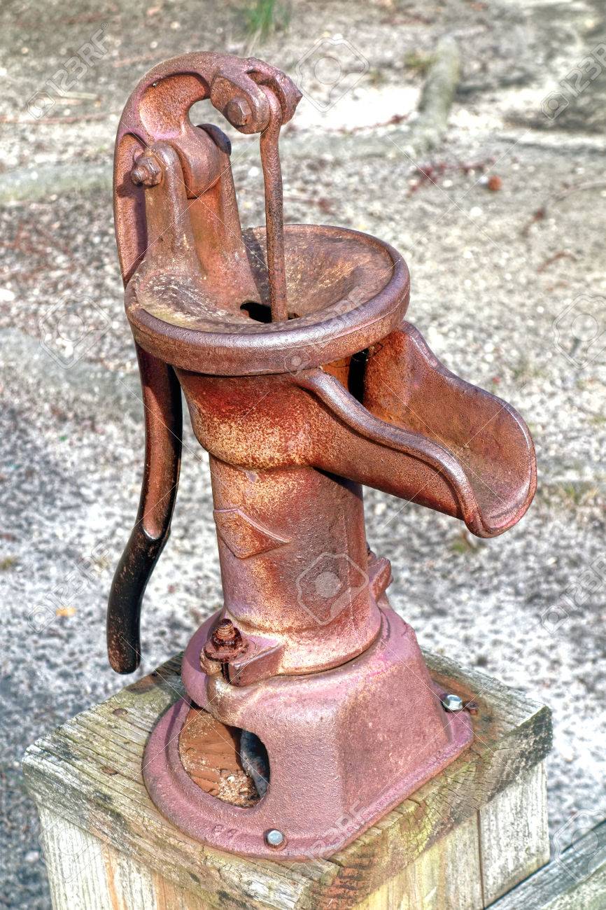 Antique style reproduction rusty manual water well pump device with hand  crank Stock Photo - 27489217