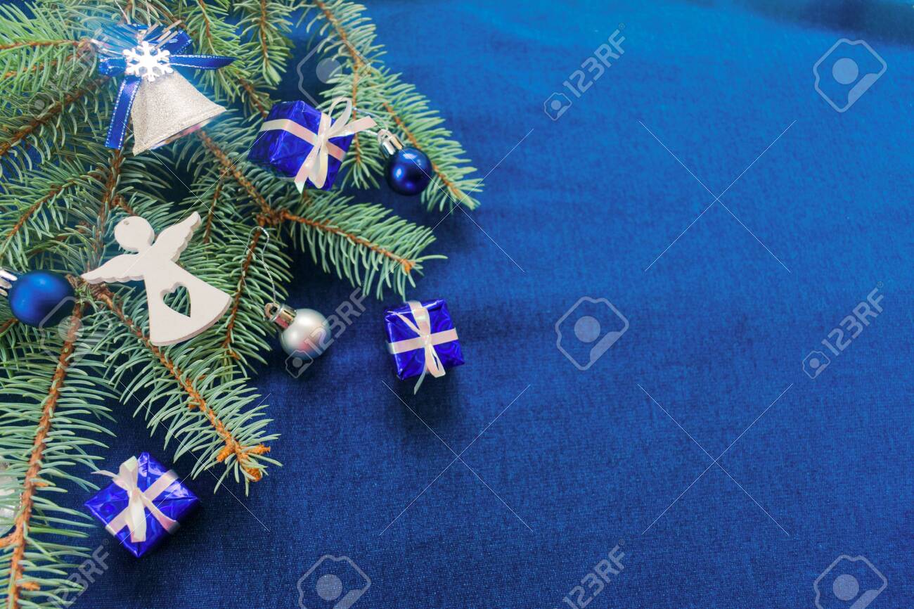Christmas Background In Blue With A Christmas Tree Branch Decorated