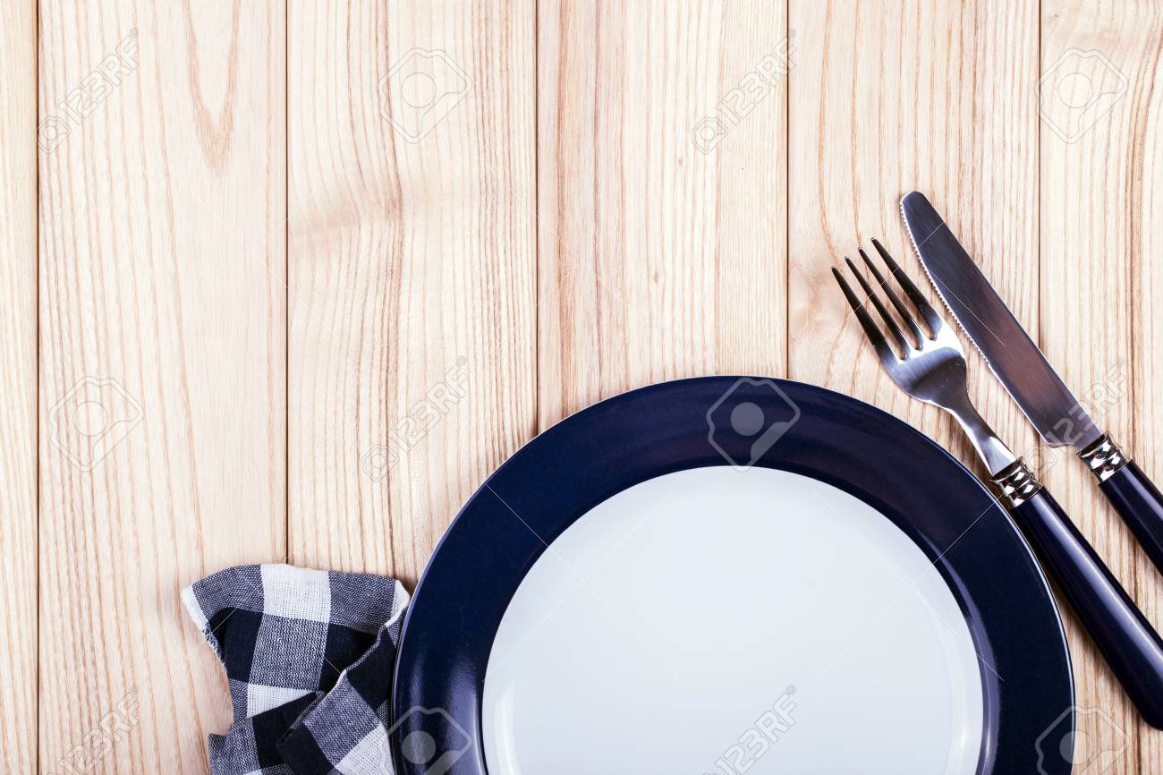 Empty dish, knife and fork and blue napkin on wood table - 40863322 Empty dish, knife and fork and blue napkin on wood table - 40863322