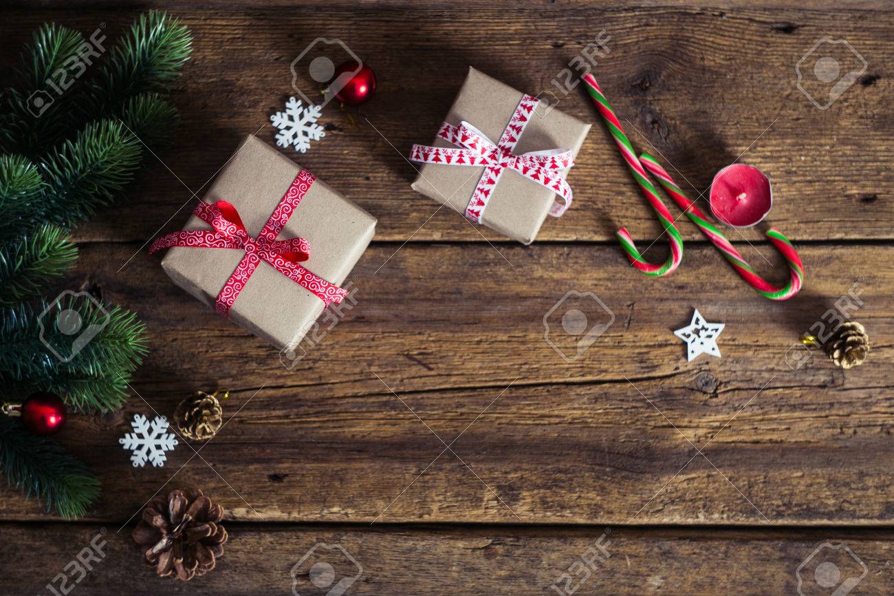Christmas presents on a wooden background with candy cane, fir branches, candle, cones. - 48977724 Christmas presents on a wooden background with candy cane, fir branches, candle, cones. - 48977724