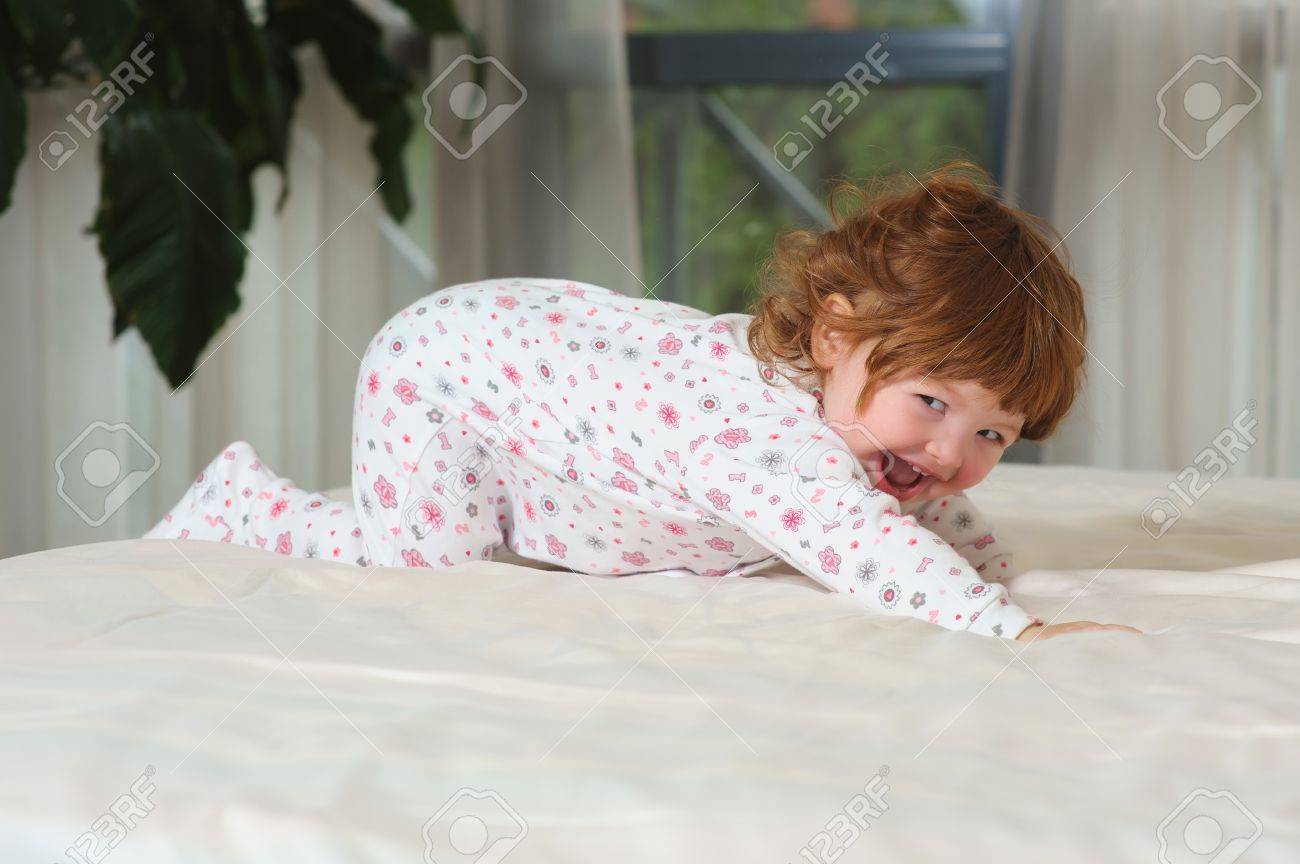 Sourire Bebe Fille Jouant Dans Une Nuit Des Vetements Sur Le Lit Dans La Chambre Avec Des Draps Blancs Heureux Recroqueville Bebe Aux Cheveux Roux Banque D Images Et Photos Libres De Droits