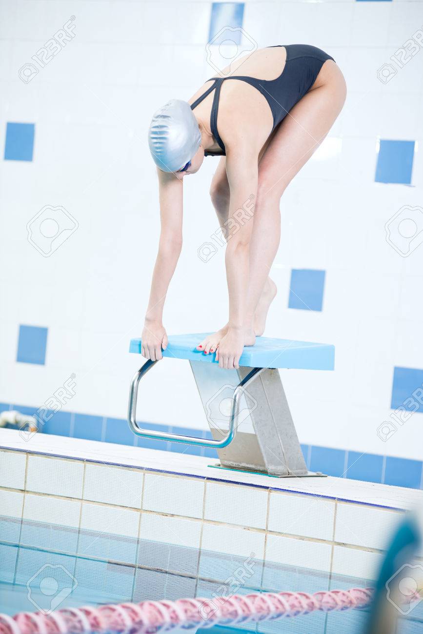 水泳帽とゴーグルを身に着けているとプールに飛び込む準備する女子水泳選手の肖像 の写真素材 画像素材 Image