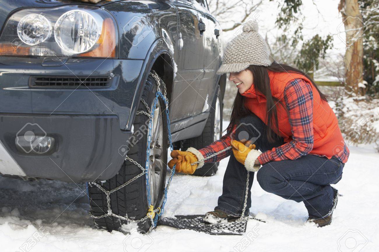 女性の車のタイヤにスノー チェーンを入れて の写真素材 画像素材 Image