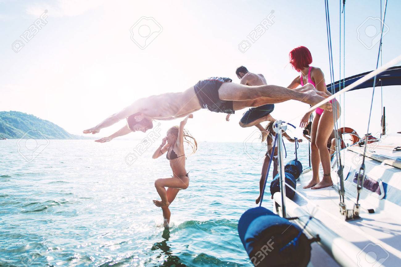 group of friends diving in the water during a boat excursion - 64360881 group of friends diving in the water during a boat excursion - 64360881