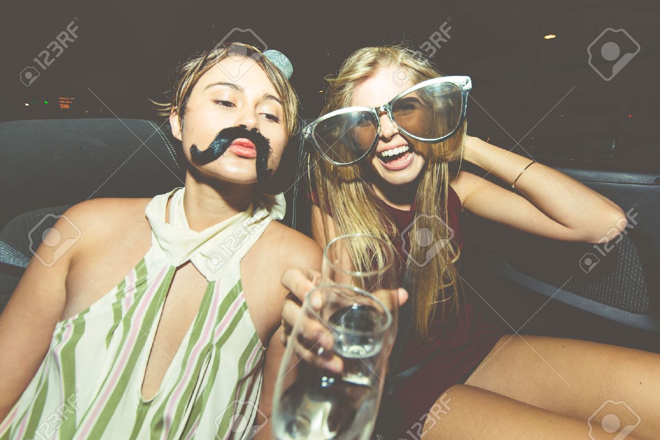 Party girls celebrate in Hollywood drinking champagne on a covertible car - 65092116 Party girls celebrate in Hollywood drinking champagne on a covertible car - 65092116