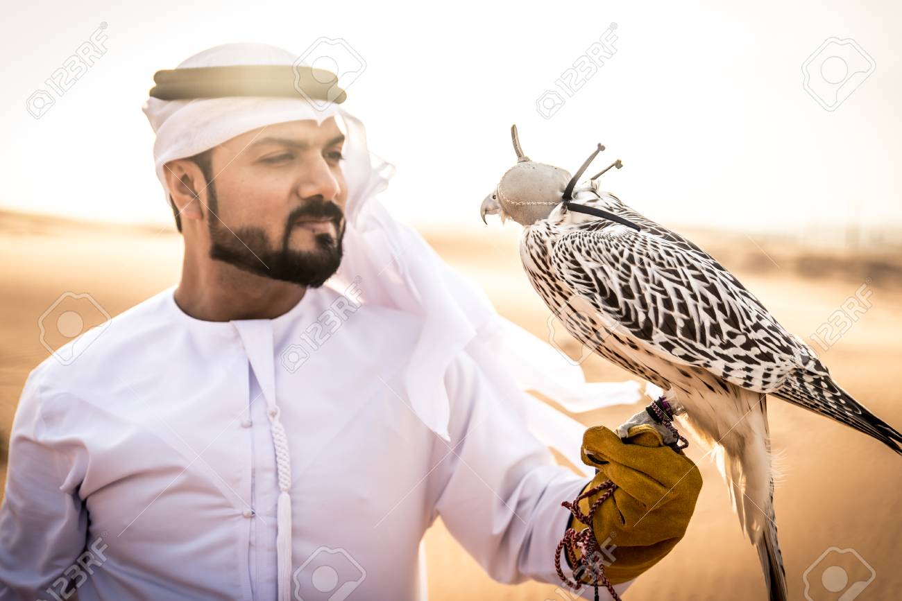 Arabic Man With Traditional Emirates Clothes Walking In The Desert