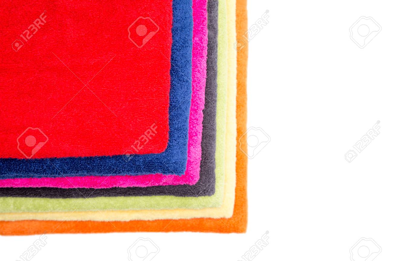 Bunter Stapel Flauschige Sauber Frische Handtucher Ordentlich Gefaltet Und Angezeigt Werden Um Ihre Farben Mit Einem Roten Oben Zeigen Von Oben Betrachtet Isoliert Auf Weiss Mit Copyspace Auf Der Rechten Seite Lizenzfreie