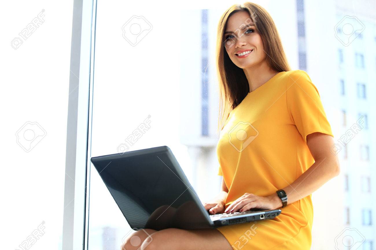 Portrait of a young business woman using laptop at office - 48284619 Portrait of a young business woman using laptop at office - 48284619