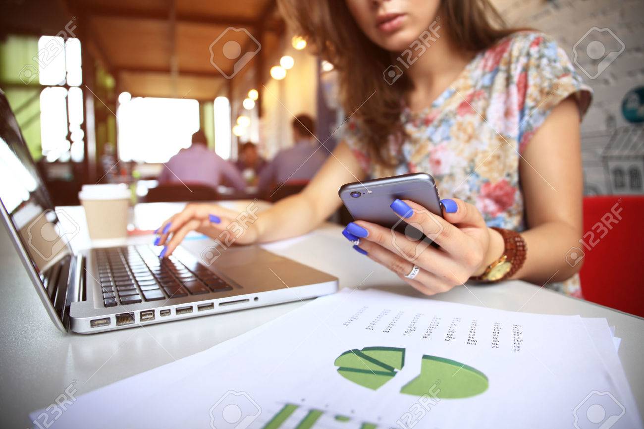businesswoman using internet on smart phone and laptop - 65005816 businesswoman using internet on smart phone and laptop - 65005816
