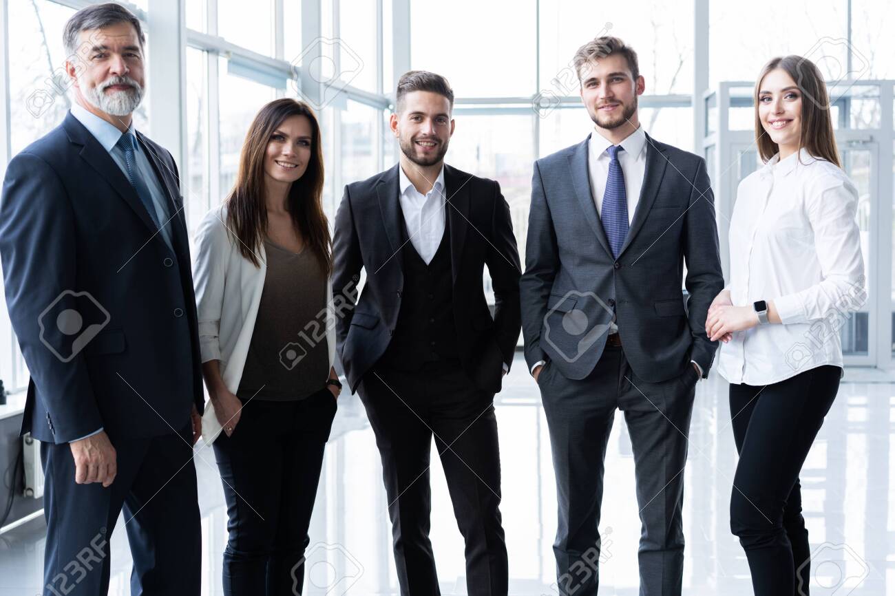 Full length confident business team stands in office. - 122628146 Full length confident business team stands in office. - 122628146