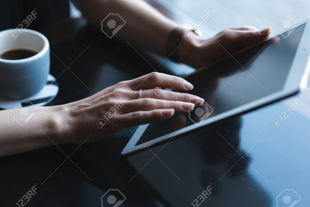 Close up of hands woman using her tablet pc in restaurant,cafe - 124623370 Close up of hands woman using her tablet pc in restaurant,cafe - 124623370