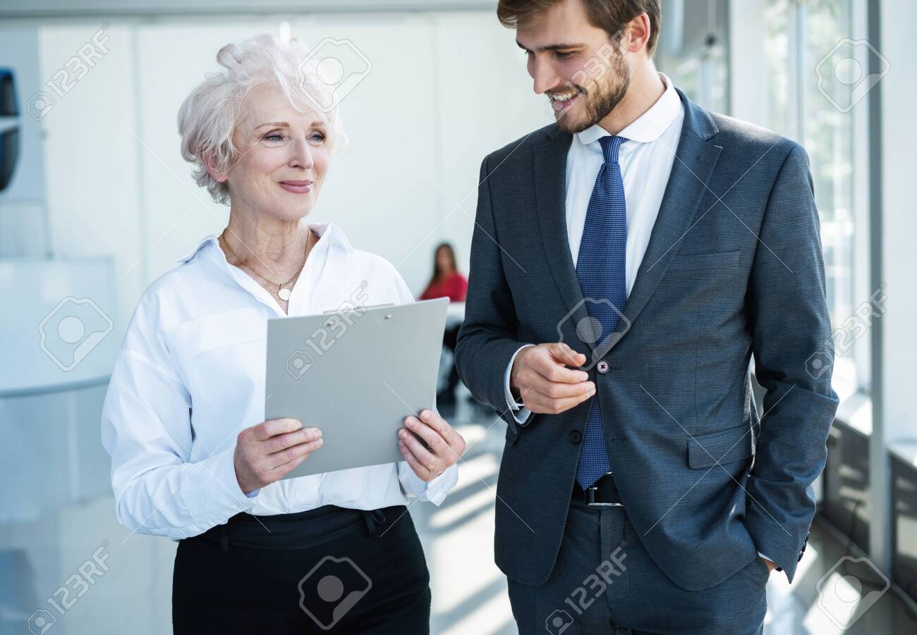 Senior mature caucasian female executive ceo discuss report with young colleague - 131810620 Senior mature caucasian female executive ceo discuss report with young colleague - 131810620