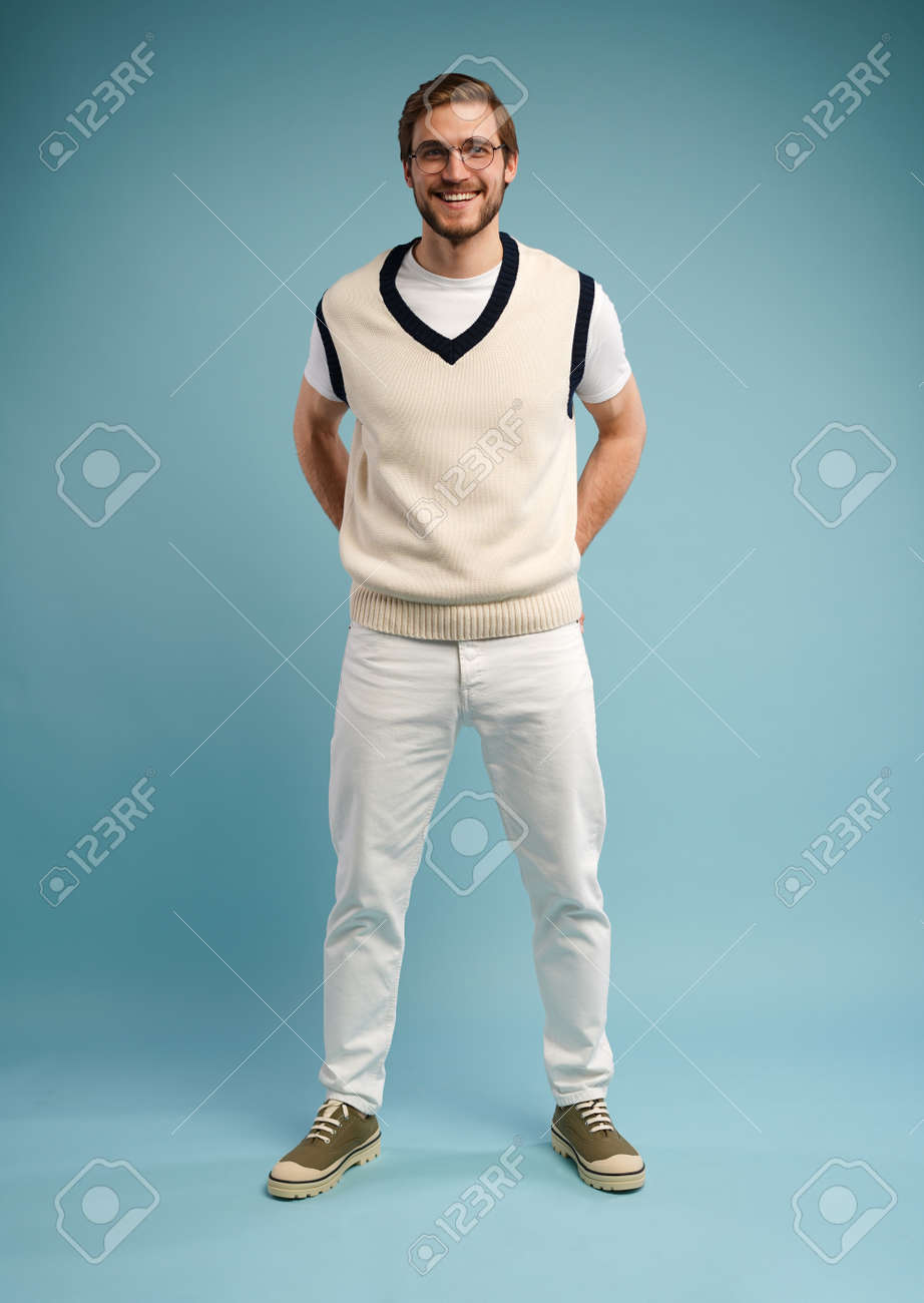 Full length of cheerful charming cute handsome man posing in front of camera isolated over blue color background - 171574569 Full length of cheerful charming cute handsome man posing in front of camera isolated over blue color background - 171574569
