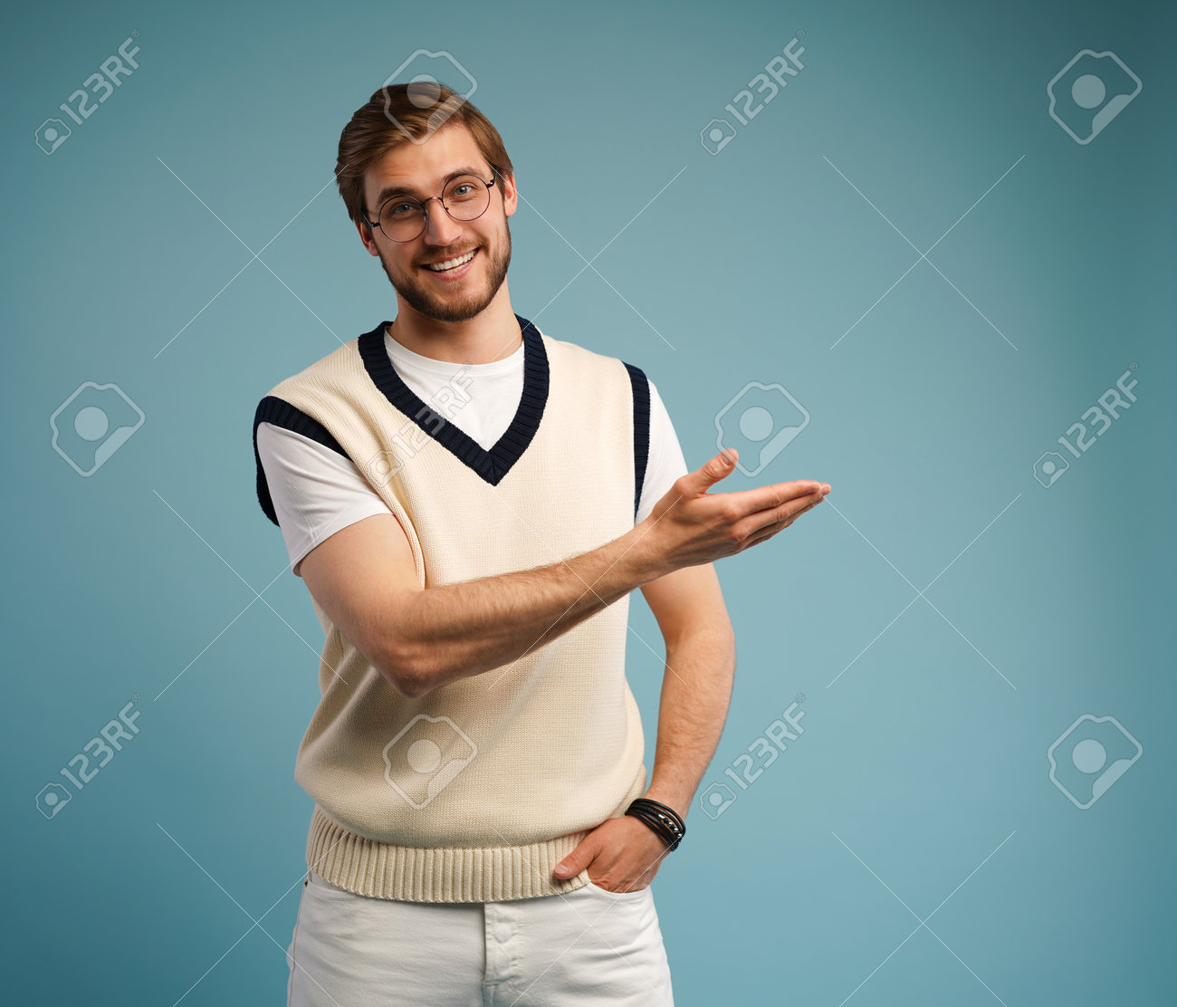 Portrait of a happy young man in casual pointing fingers away at copy space isolated over blue background. - 171574349 Portrait of a happy young man in casual pointing fingers away at copy space isolated over blue background. - 171574349
